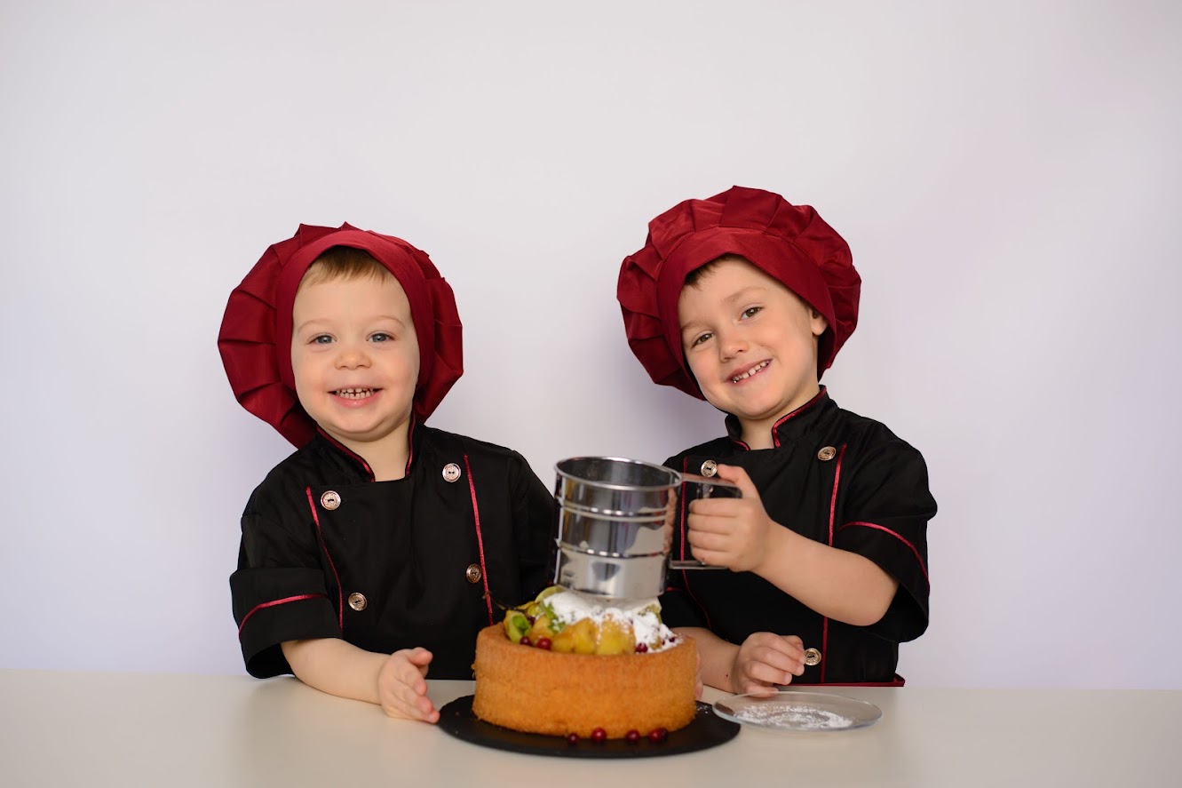 два мальчика кулинара в поварской одежде на кулинарном мастер-классе