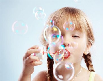 Девочка пускает мыльные пузыри